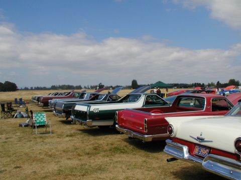 1967 Ford Ranchero - Multiple 1967 Ford Rancheros are lined up at a car show on a sunny day.