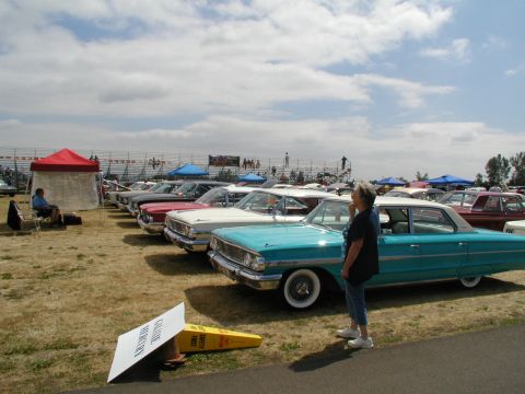 1967 Ford Ranchero - A turquoise 1964 Ford sedan is displayed at a car show, with other classic vehicles lined up in the background.