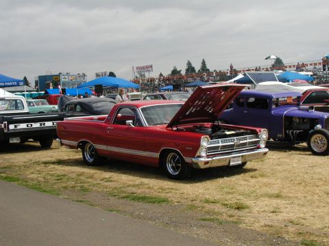1967 Ford Ranchero - A red 1967 Ford Ranchero is displayed with its hood open at an outdoor car show.