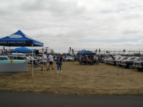 1967 Ford Ranchero - Attendees browse classic cars and vendor tents at an outdoor car show event.