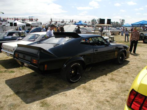 1967 Ford Ranchero - A black 1977 Ford Falcon XB coupe with a prominent rear spoiler is displayed at a car show.