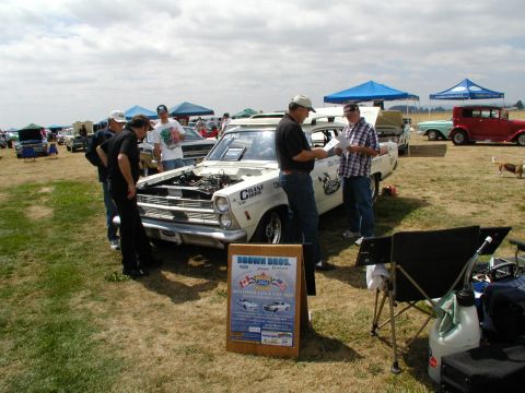 1967 Ford Ranchero - 1967 Ford Ranchero on display at a car show with people examining the engine.