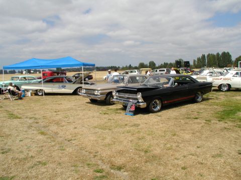 1967 Ford Ranchero - Black 1967 Ford Ranchero GT with red stripe, parked at car show with other vehicles.