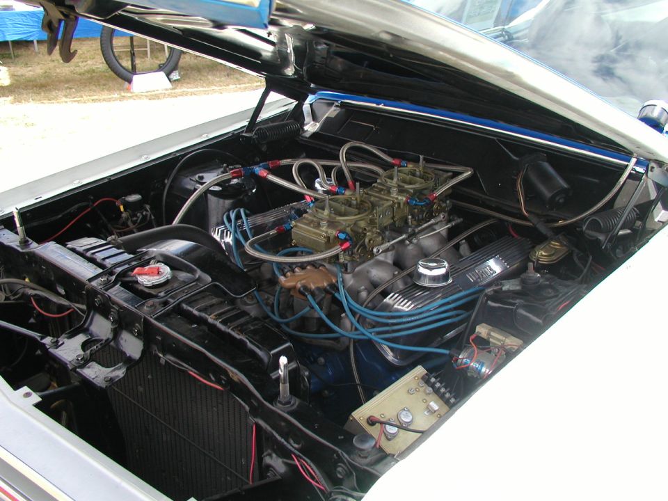 1967 Ford Ranchero engine bay with dual carburetors and blue wiring