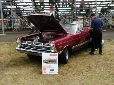 1967 Ford Ranchero - A red 1967 Ford Fairlane 500XL convertible is displayed with its hood open at a car show.