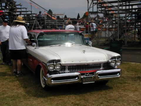 1967 Ford Ranchero - A two-tone 1957 Mercury Montclair is displayed at a car show, a prominent chrome grille and dual headlights.