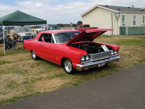 1967 Ford Ranchero - A red 1966 Ford Fairlane coupe is displayed with its hood open at an outdoor event.