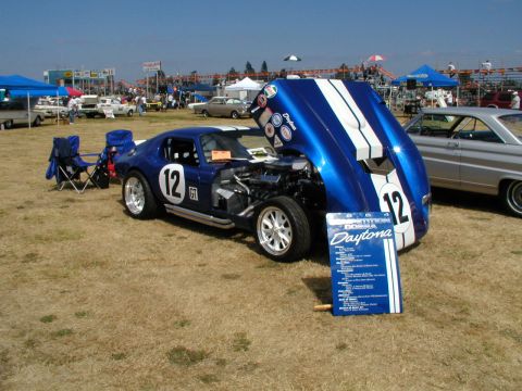1967 Ford Ranchero - A blue race car with white stripes and number 12 is displayed with its hood open at an outdoor event.