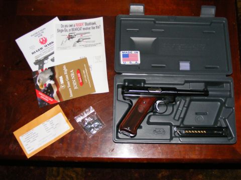 2006 Ford F-250 - Ruger Mark pistol and accessories laid out on a wooden table.
