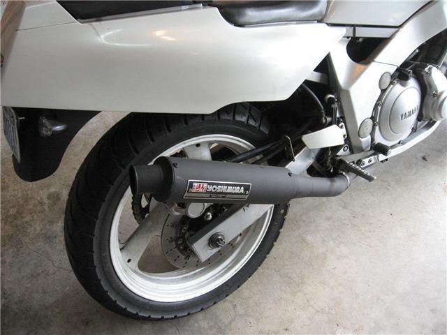 Close-up of a motorcycle's rear wheel and Yoshimura exhaust pipe