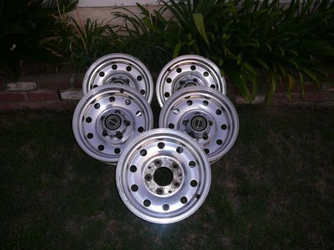 1988 Ford Bronco - Set of five aluminum wheels, likely for a truck or SUV, displayed on grass.