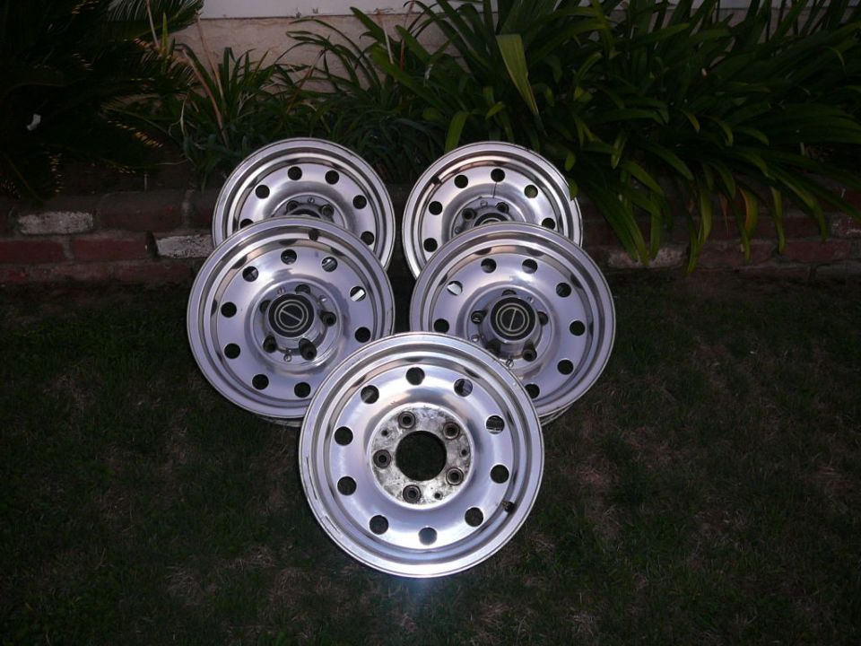 Five aluminum wheels with black lug nuts and center caps