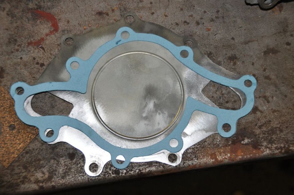 Water pump gasket with blue sealant on metal surface