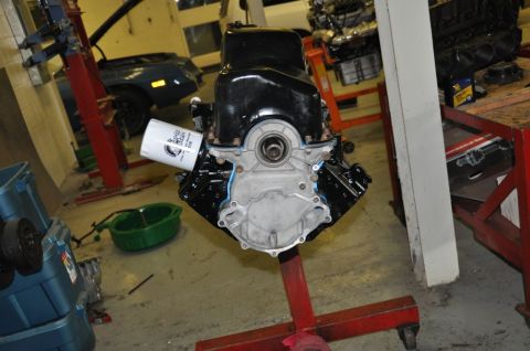 1996 Ford Bronco - Engine on a stand in a garage, with an oil filter and drain pan visible.