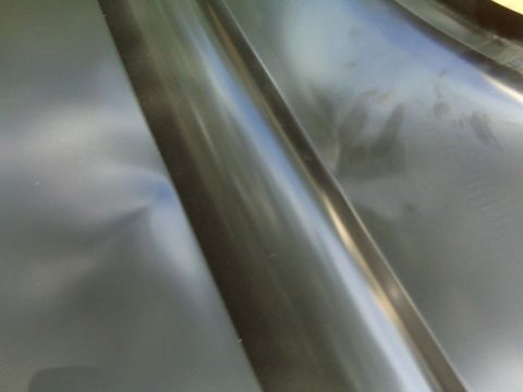 1979 Ford Bronco - Close-up of an interior metal panel, showing a dent and the texture of the surface.