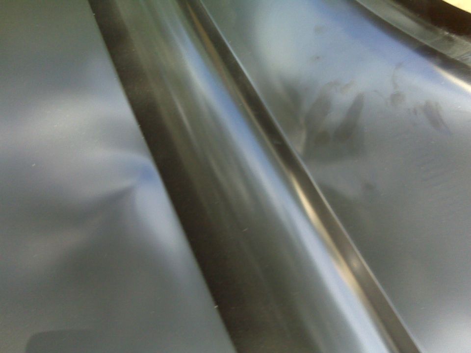 Interior metal panel with a dent and reflections