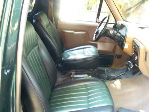 1990 Ford Bronco - Interior view of a 1990 Ford Bronco, green and black upholstery on the bucket seats and a tan dashboard.