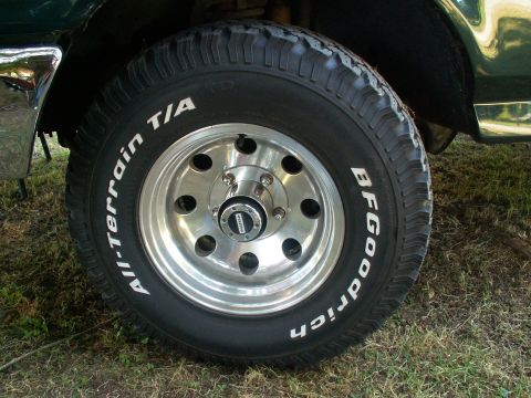 1990 Ford Bronco - A close-up view of a vehicle's tire and wheel assembly, BFGoodrich All-Terrain tires.