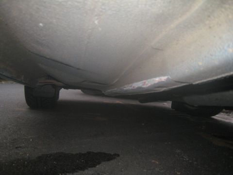 2007 Subaru Impreza - Damage to the rocker panel and undercarriage of a vehicle is visible.