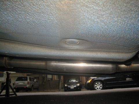 2007 Subaru Impreza - The undercarriage of a vehicle is shown, with other cars parked behind it.