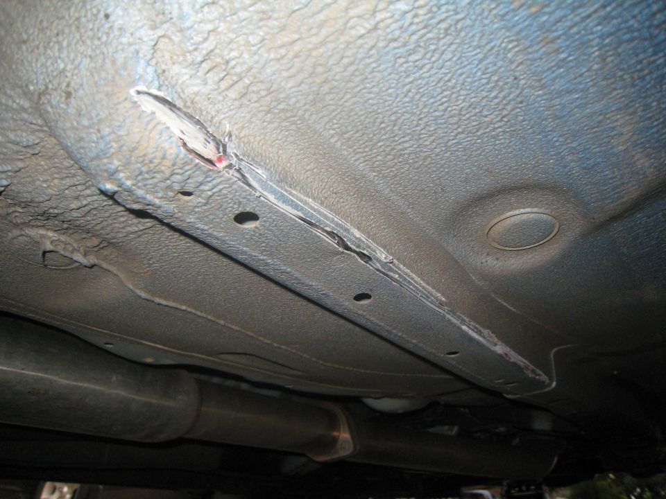 Underside of car floorpan with seam sealer stripped to bare metal
