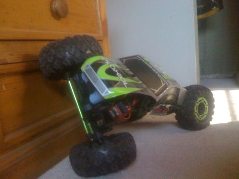 1995 Ford Bronco - A remote control rock crawler sits on a carpeted floor, leaning against a wooden dresser.
