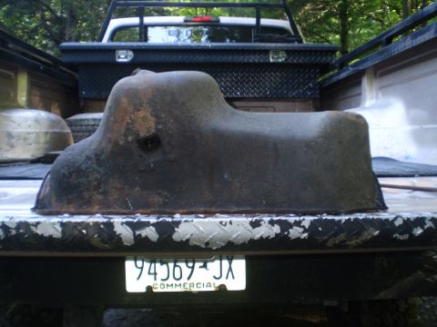 1979 Ford Bronco - A weathered oil pan is positioned in the back of a pickup truck, obscuring the license plate.