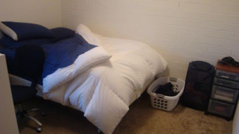 1996 Ford Bronco - A bedroom scene with a bed, laundry basket, and storage drawers is shown.
