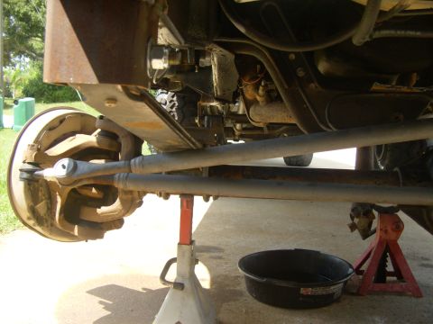 1995 Ford Bronco - Vehicle's front axle and suspension components are visible, supported by jack stands.