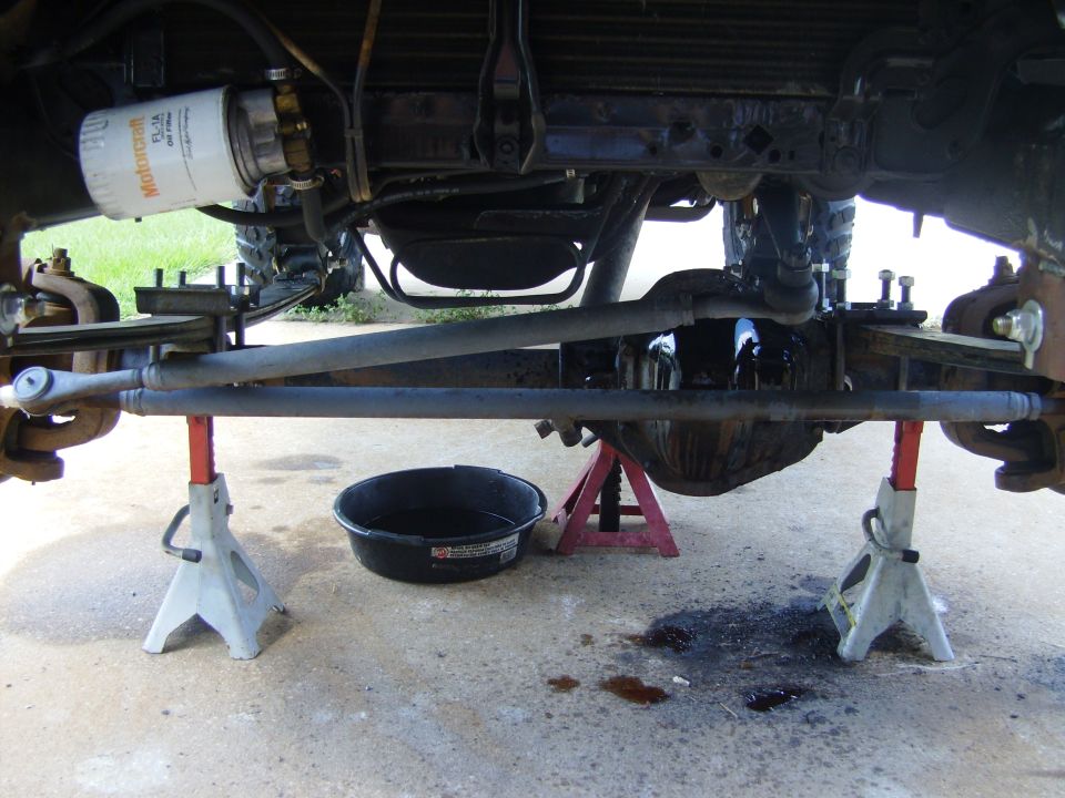 Underside of truck on jack stands showing front axle, Motorcraft oil filter and drain pan