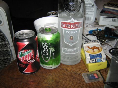 2000 Mercury Grand Marquis - Beverages and cigarettes are arranged on a table next to a fan.