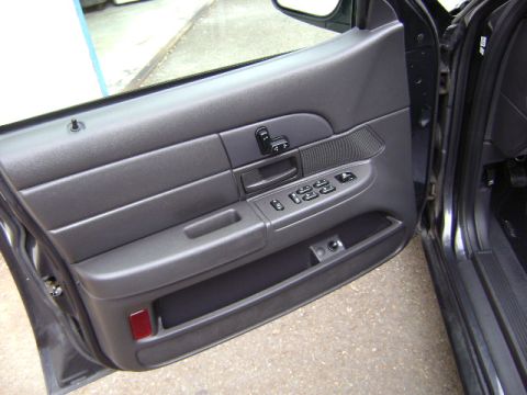 2001 Ford Crown Victoria - Close-up of the interior door panel, showing the power window controls and a storage area.