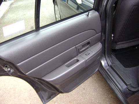 2001 Ford Crown Victoria - Interior view of a 2001 Ford Crown Victoria, focusing on the driver's side door panel and window controls.