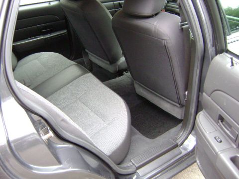 2001 Ford Crown Victoria - Interior view of the rear seating area of a dark gray vehicle, showing fabric and vinyl upholstery.