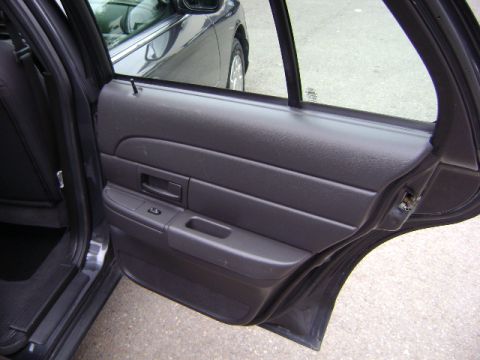 2001 Ford Crown Victoria - Interior view of a car's rear door panel, with another vehicle reflected in the window.