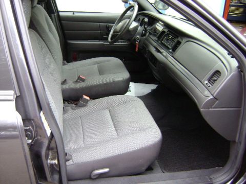 2001 Ford Crown Victoria - The interior of a Ford Crown Victoria is shown, cloth seats and the dashboard area.