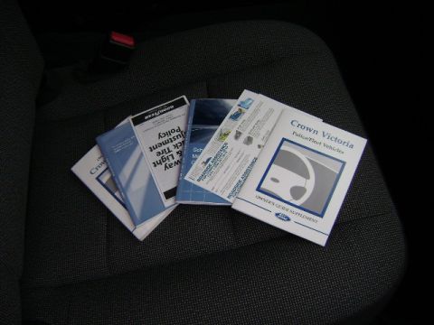 2001 Ford Crown Victoria - Owner's guide supplement for Crown Victoria Police/Fleet Vehicles and other manuals are shown on a car seat.