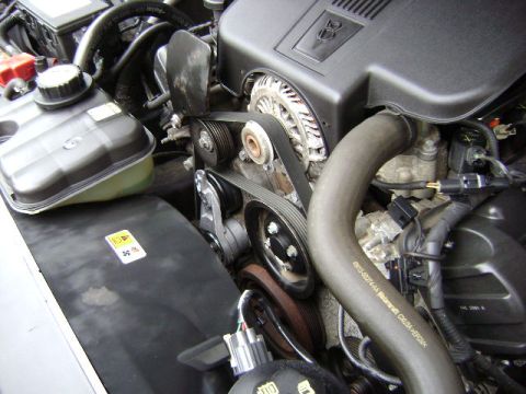 2001 Ford Crown Victoria - Close-up of an engine bay showing the V8 engine cover, serpentine belt system, and coolant reservoir.