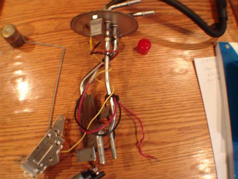 1996 Ford Bronco - Fuel pump assembly with float arm and wiring is laid out on a wooden table.