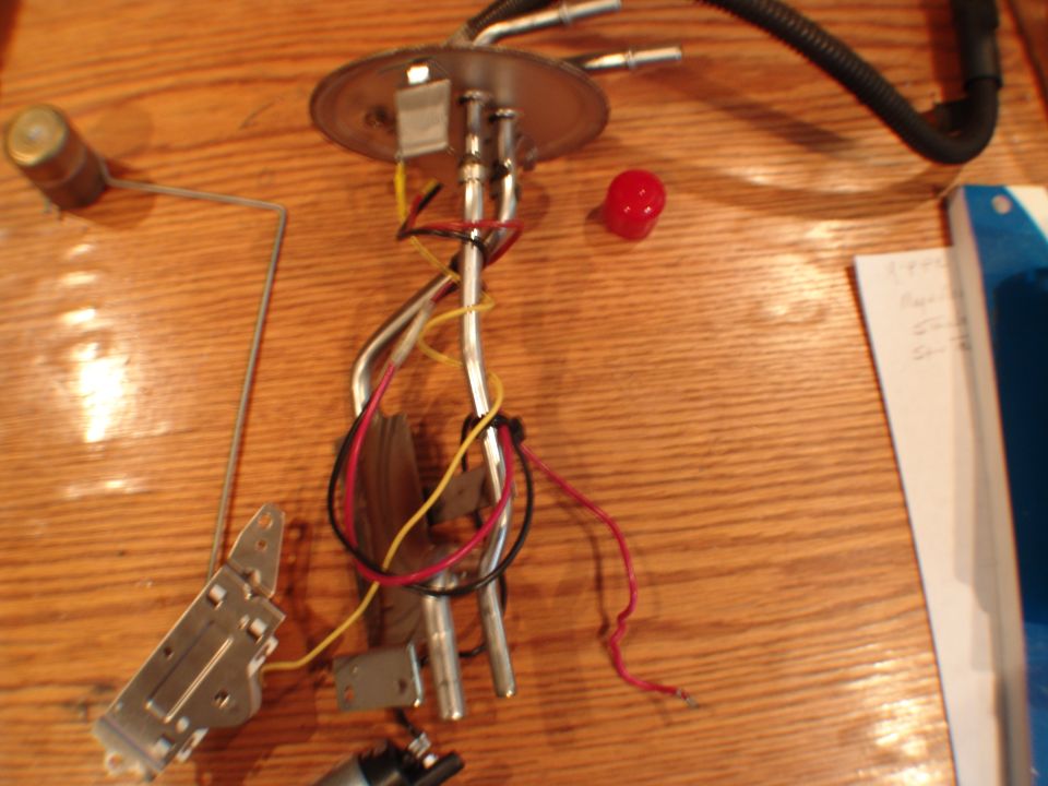 Fuel pump assembly with float arm and wiring on a wooden surface