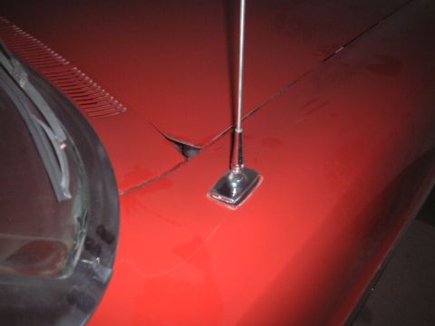 1967 Ford Galaxie - Close-up of the hood of a red 1967 Ford Galaxie, showing the antenna and part of the windshield.
