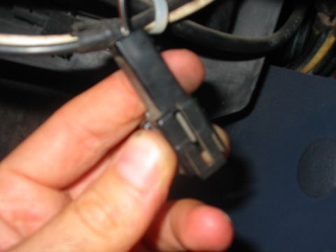 1992 Ford Bronco - Close-up of a hand holding an electrical connector with visible wires and zip ties.