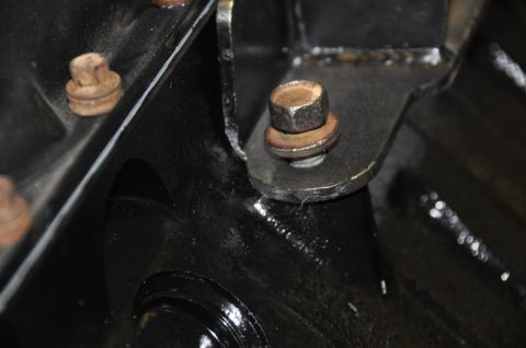 1996 Ford Bronco - A close-up view of a vehicle's engine bracket and fasteners.