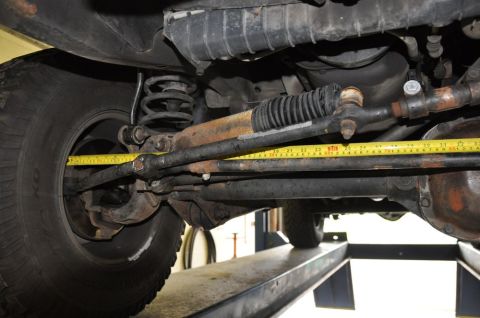 1996 Ford Bronco - Close-up view of vehicle steering components, with a tape measure indicating a measurement.