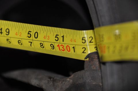 1996 Ford Bronco - A yellow measuring tape is used to measure a rusty bolt, with markings visible from 50 to 52 inches.
