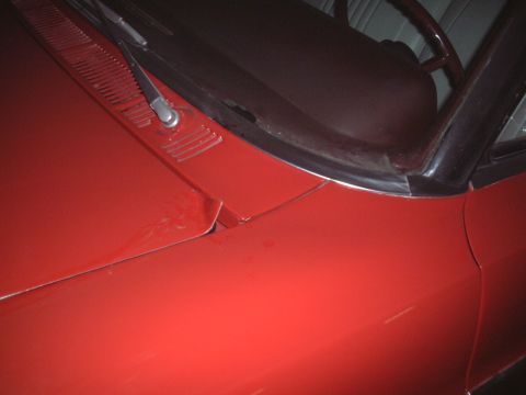 1967 Ford Galaxie - Close-up view of the front section of a red car, focusing on the hood and windshield area.