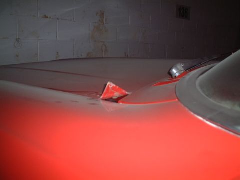 1967 Ford Galaxie - The distinctive red hood ornament on a 1967 Ford Galaxie is visible, along with a portion of the car's hood and windshield trim.