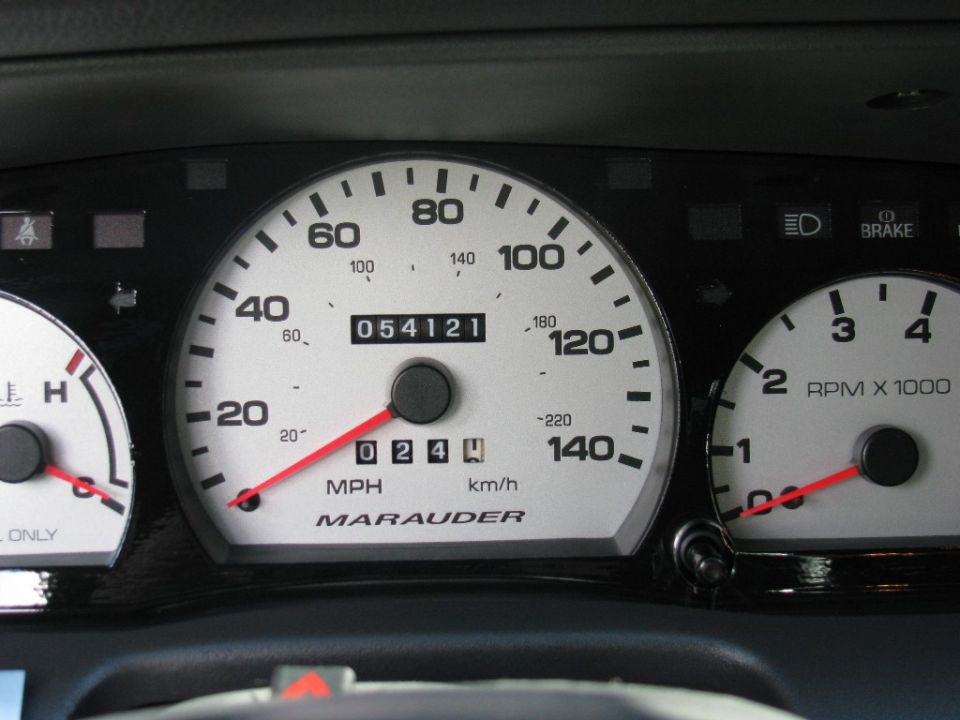 Close-up of white-faced Marauder speedometer with odometer showing 054121 miles