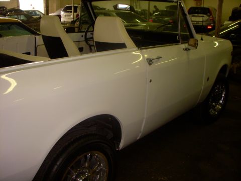 1993 Ford Bronco - A white convertible SUV is parked indoors, with other vehicles visible in the background.