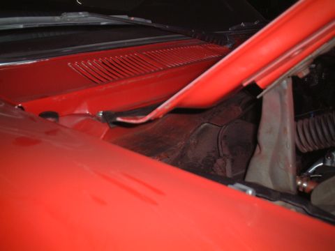 1967 Ford Galaxie - The hood is open on a red car, revealing the engine bay and a portion of the windshield.